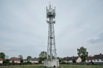 Antenne 5G moderne installée dans un environnement suburban avec des maisons en arrière-plan, illustrant la portée du signal en milieu résidentiel