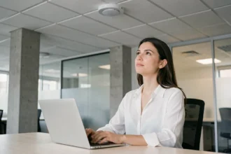 Femme utilisant une connexion LiFi via un panneau LED au plafond dans un bureau moderne